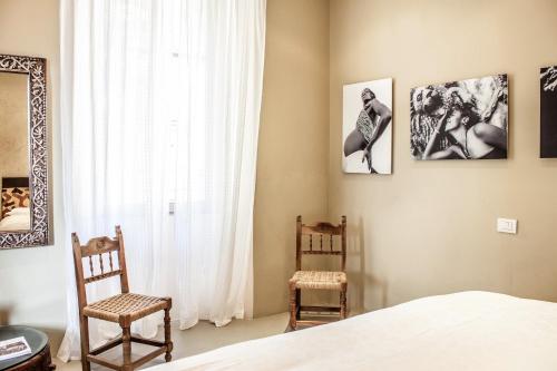 um quarto com 2 cadeiras, uma cama e uma janela em Delightful a Few Steps From Port em Como