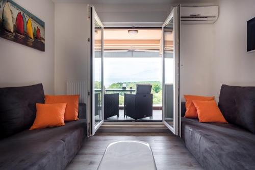 a living room with two couches and a balcony at Monte Paradiso Panorama in Pula