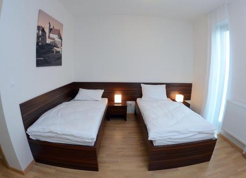 two beds in a room with two lamps on them at Hotel Bélier in Prešov