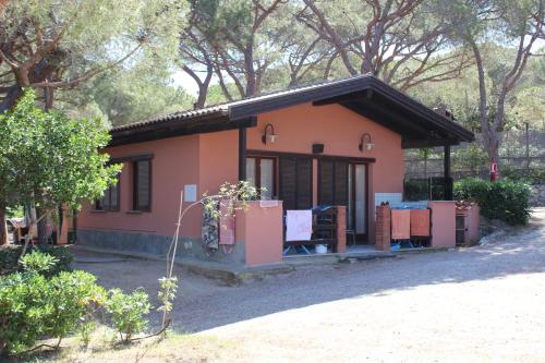 a small orange house with a lot of windows at Camping Lacona Pineta in Capoliveri