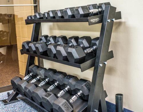 a rack of dumbbells hanging on a wall at Ramada by Wyndham Alpena in Alpena