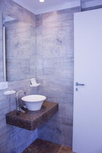 a bathroom with a white bowl sink on a counter at San Remo New Viking in Pinamar