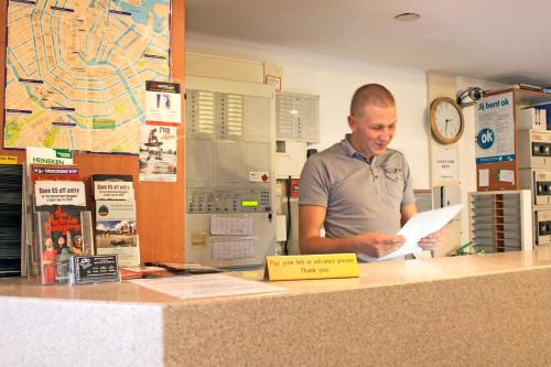 a man standing at a counter holding a paper at Koopermoolen in Amsterdam