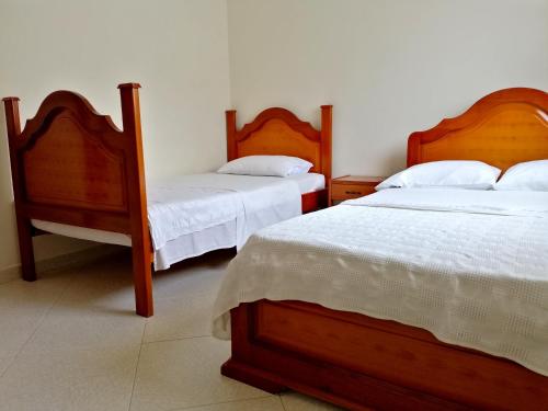 a bedroom with two beds with white sheets at Hotel el Paraíso del Valle in Valle de San José