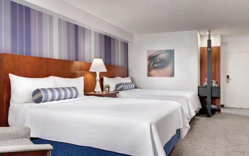 a hotel room with two beds and a chair at Luxor in Las Vegas