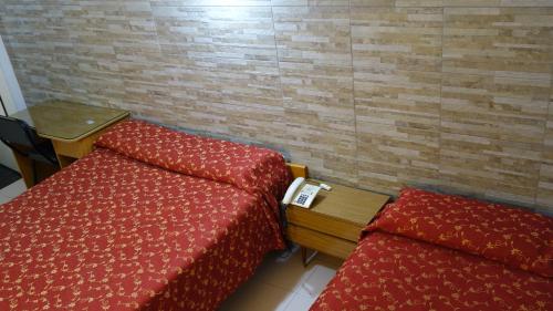 a room with two beds and a desk and a table at Hotel KEY´S in Buenos Aires