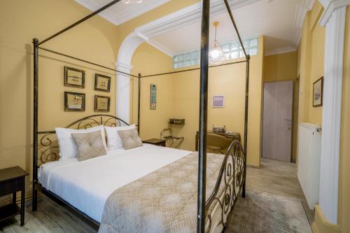 ein Schlafzimmer mit einem großen weißen Bett in einem Zimmer in der Unterkunft Kentrikon deluxe Apt.(must) in Thessaloniki