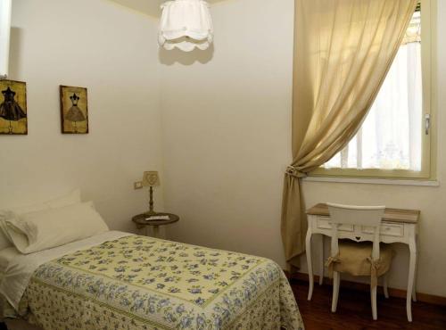 a bedroom with a bed and a table and a window at B&B Il Bijou in Casalmaggiore
