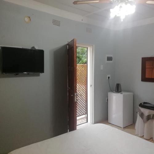 Una habitación con un televisor de pantalla plana en la pared. en Ankuweni Guest house, en Giyani