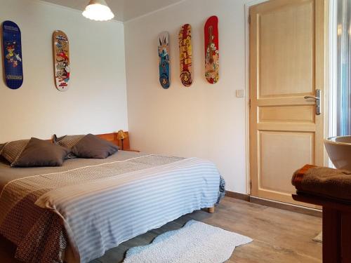 1 dormitorio con cama y tablas de surf en la pared en Chambre d'hôtes aux Pays des Sucs, en Saint-Hostien