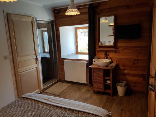 uma casa de banho com uma cama, um lavatório e um espelho. em Chambre d'hôtes aux Pays des Sucs em Saint-Hostien