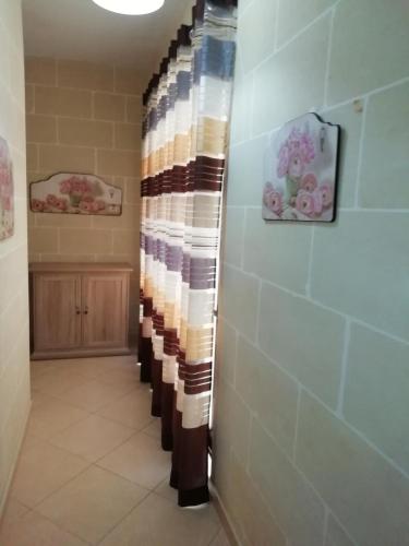 ein Badezimmer mit einer Reihe gestreifter Duschvorhänge in der Unterkunft San Anton Apartment in Xagħra