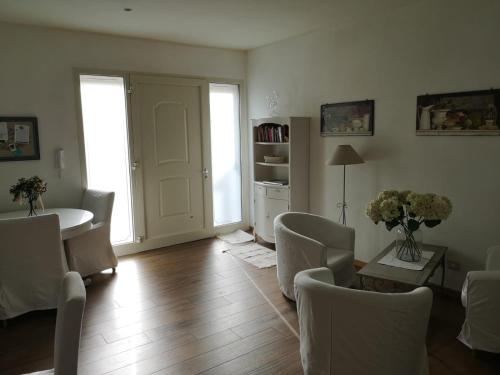 a living room with white furniture and a table and chairs at B&B Il Bijou in Casalmaggiore