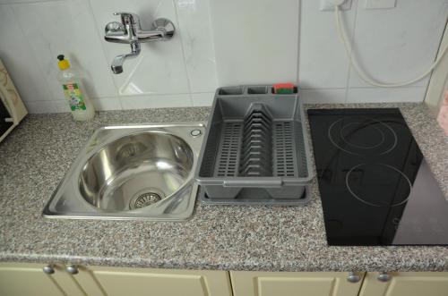 a kitchen sink with a dish drying rack next to it at Ema & Sea Apartment's in Pula