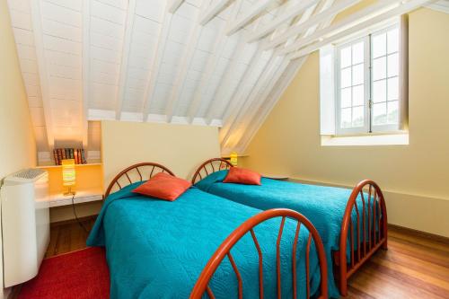 a bedroom with two beds and a window at Casa Dos Barcos Furnas in Furnas