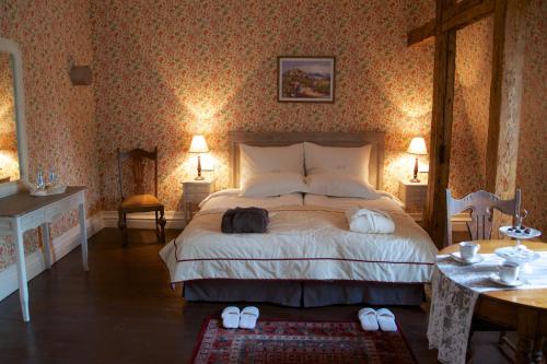 a bedroom with a bed with two slippers on it at Liepupe Manor in Liepupe