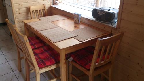 a wooden table with four chairs and a window at Villa Svalyavа in Svalyava