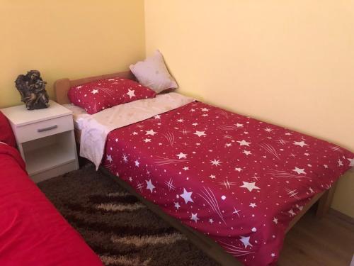 una camera da letto con un letto con un piumone rosso con stelle di Relax Apartment a Bajina Bašta