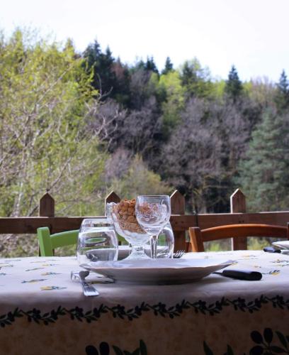 a table with wine glasses and a plate of food at Chticabane in Taintrux