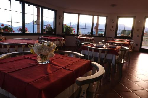 コーレドにあるLa Capanninaの赤いテーブルクロスのテーブルと椅子が備わるレストラン