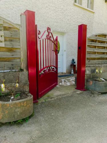 a red gate in front of a building at Chticabane in Taintrux