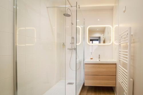 une salle de bain blanche avec une douche et un lavabo dans l'établissement Hypercentre, Calme, Cosy, Parking Gratuit, Netflix Gratuit, à Toulouse