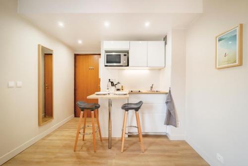 - une petite cuisine avec deux tabourets et un comptoir dans l'établissement Hypercentre, Calme, Cosy, Parking Gratuit, Netflix Gratuit, à Toulouse