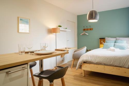 - une chambre avec un lit et un bureau avec une table et des chaises dans l'établissement Hypercentre, Calme, Cosy, Parking Gratuit, Netflix Gratuit, à Toulouse