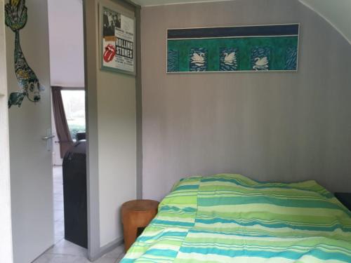 een slaapkamer met een bed en een foto aan de muur bij Iglo Bungalow 35 in Chaam