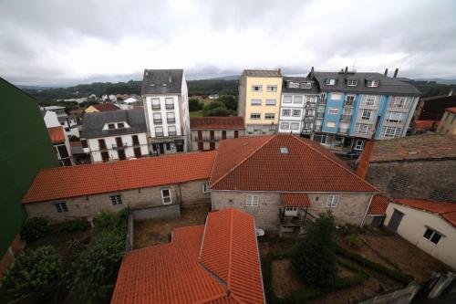 un grupo de edificios con techos rojos en una ciudad en Pension Pardellas, en Palas de Rei 