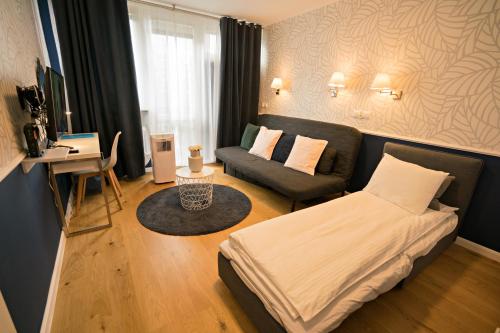 ワルシャワにあるApartament Hotel Grzybowska 9の小さなベッドルーム(ベッド1台、ソファ付)