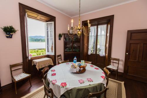 a dining room with a table with flowers on it at Casa da Lagoa in Furnas