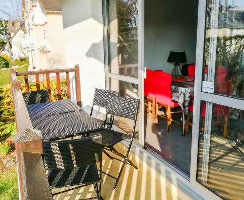 un patio avec une table et des chaises sur un porche dans l'établissement Cabourg centre, appartement pour 4 personnes à 100m de la mer, à Cabourg