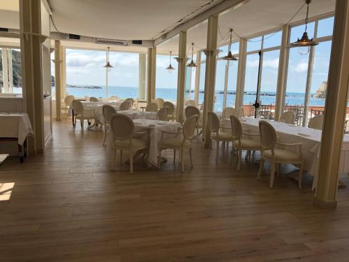 a dining room with tables and chairs and the ocean at Hotel Miramare & Spa in Sestri Levante