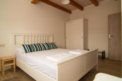 a bedroom with a white bed and a cabinet at Mama Residence in Rovinjsko Selo