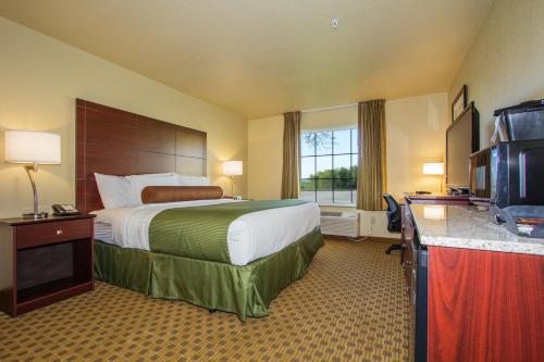 a hotel room with a bed and a television at Cobblestone Inn & Suites - Linton in Linton