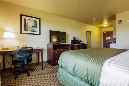 a hotel room with a bed and a desk and a computer at Cobblestone Inn & Suites - Linton in Linton
