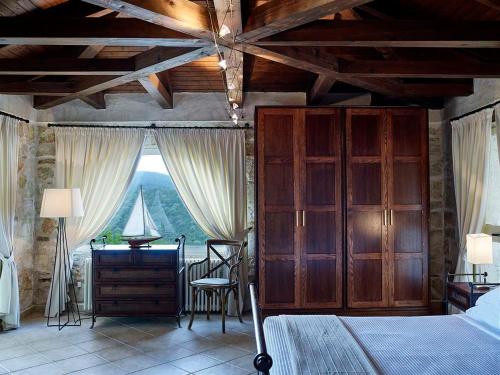 una camera con letto, scrivania e finestra di Villa Ioli- Beachfront Luxury Residence a Igoumenítsa