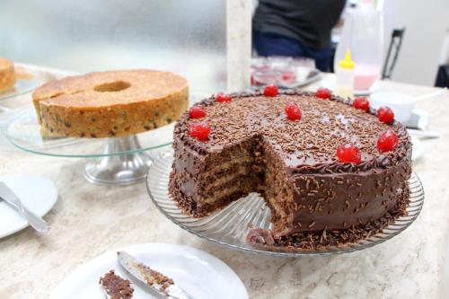 a chocolate cake on a table with a slice missing at Hotel Pousada da Serra in Maracaju
