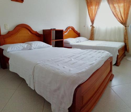 a bedroom with two beds with white sheets at Hotel el Paraíso del Valle in Valle de San José