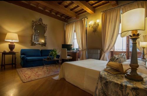 a bedroom with a bed and a blue couch at Capri Moon Guest House in Florence