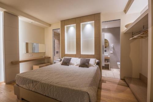 a bedroom with a large bed and a bathroom at Villa Margherita Wellness & Golf - "Your Private Punta Ala" in Punta Ala