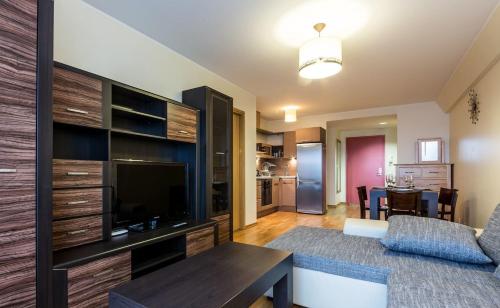 a living room with a couch and a tv and a table at Jõe Apartments in Tallinn