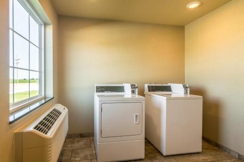a laundry room with two machines and a window at Cobblestone Inn & Suites - Lakin in Lakin