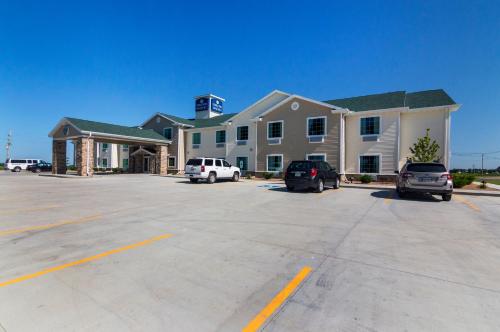 a large building with cars parked in a parking lot at Cobblestone Inn & Suites - Lakin in Lakin