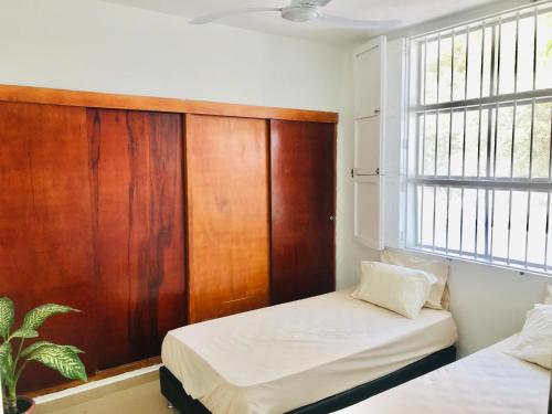 a bedroom with two beds and a wooden wall at Calle de la iglesia 35-59 in Cartagena de Indias