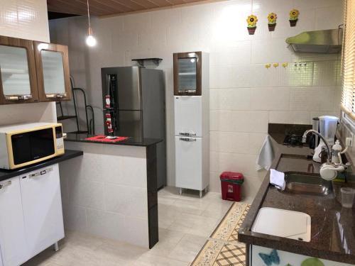 uma cozinha com um frigorífico e um micro-ondas em Chale Premium Casal e Chale Charming Casal em Mairiporã