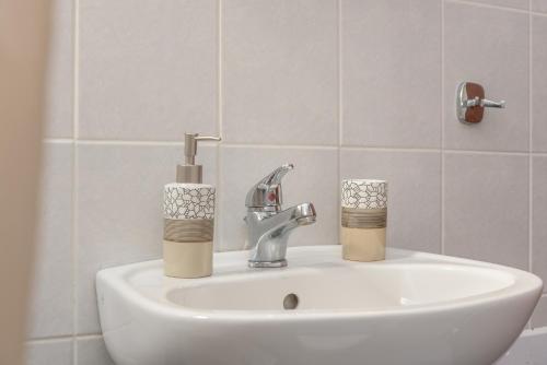 a bathroom sink with a faucet and two candles on it at Sergios Apartments 13 in Alexandroupoli