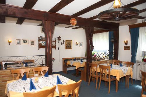 um restaurante com mesas e cadeiras e um tecto em Hotel & Restaurant - Gasthaus Brandner em Trendelburg