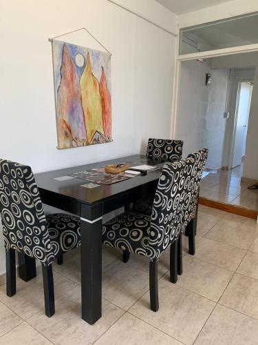 a black table with two chairs and a painting on the wall at Lo de ANNA in Posadas